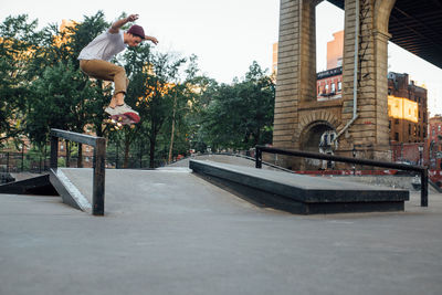 Man skateboarding in front of built structure