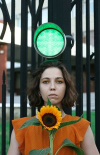 Portrait of beautiful woman standing by potted plant