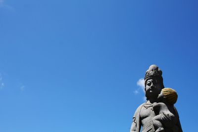 Low angle view of statue against blue sky