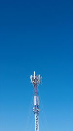 Low angle view of crane against clear blue sky