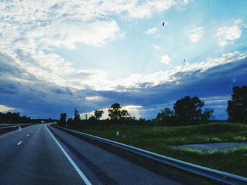 Empty road against cloudy sky