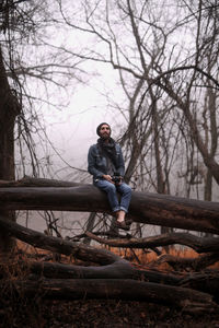 Full length of man sitting on snow covered landscape