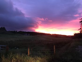 Scenic view of dramatic sky over land during sunset