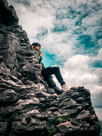 Low angle view of man climbing on rock