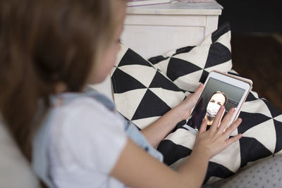 Girl using mobile phone on sofa at home