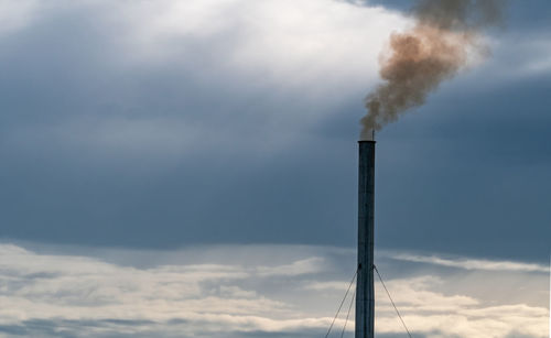 Low angle view of smoke emitting from chimney against sky. air pollution from factory. 