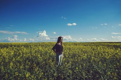 Woman standing on field against sky