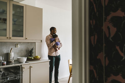 Man standing by window at home