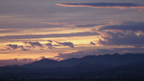 Scenic view of silhouette mountains against sky during sunset