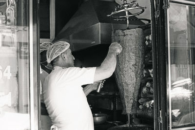 Side view of man working at window