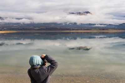 Unrecognizable teenage wearing jacket and warm clothes is practicing taking pictures