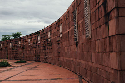 Brick wall of old building against sky
