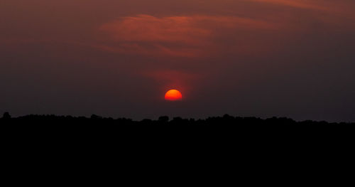 Silhouette landscape against sky at sunset