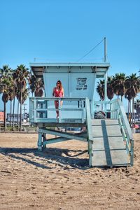 Men standing by palm trees against clear sky