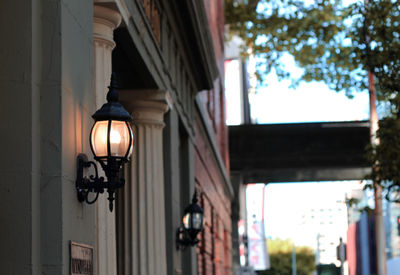 Low angle view of illuminated street light against building