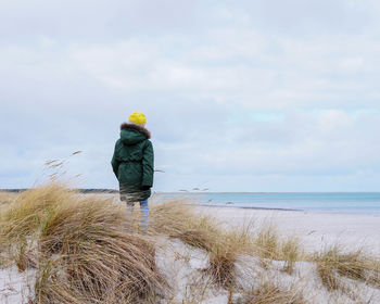 Rear view of man standing on beach