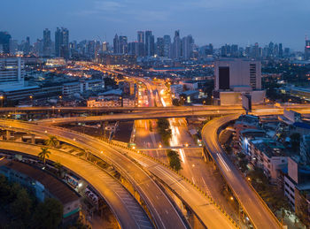 High angle view of light trails on road amidst buildings in city