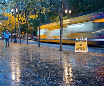 Road sign on wet street in city