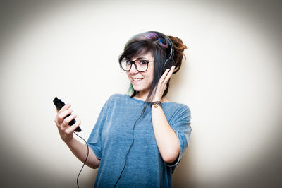 Young woman using mobile phone against white background