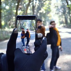 Rear view of people photographing on mobile phone