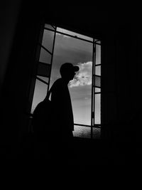 Side view of silhouette man standing by window