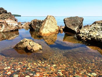 Rocks on beach against clear sky