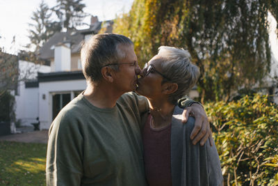 Affectionate senior couple embracing and kissing in garden