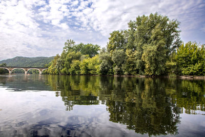 Scenic view of lake by trees against sky