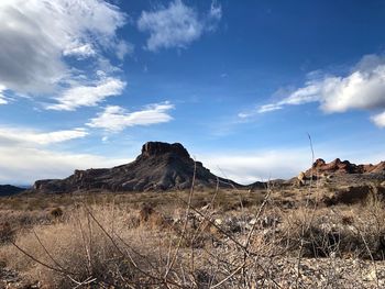 Scenic view of field by mountain against sky