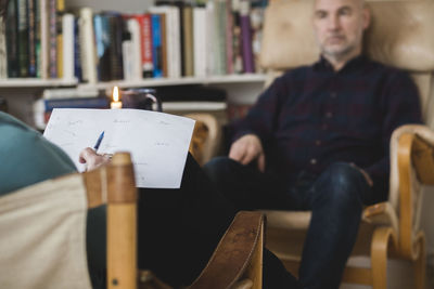 Therapist reading paper and discussing with male patient during session