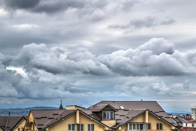 Houses against cloudy sky