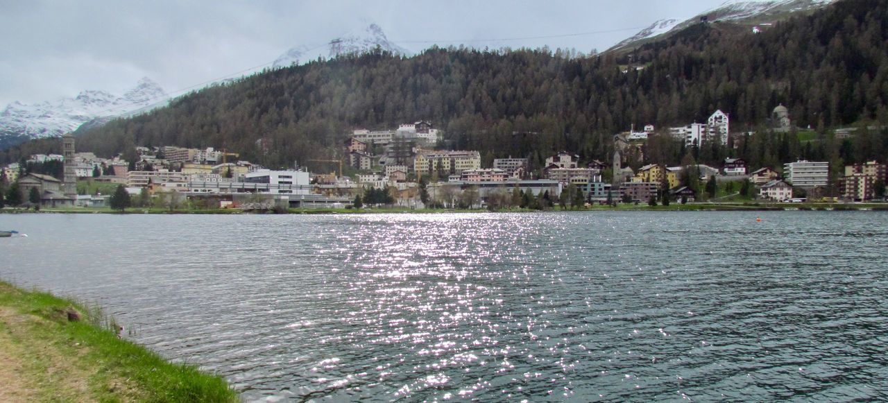 BUILDINGS BY LAKE AGAINST SKY