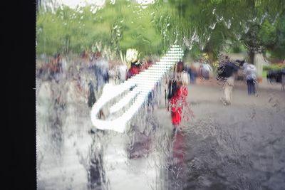 People walking on wet road during rainy season