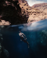 An adult man swimming in a swimsuit in the sea