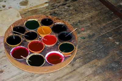 High angle view of color water in bowl on wooden table