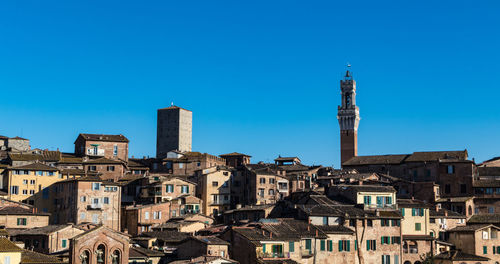 Buildings in city against blue sky