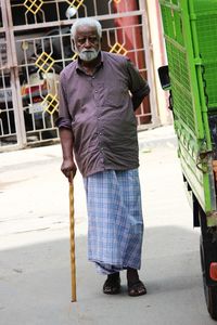 Senior man looking away while standing on street