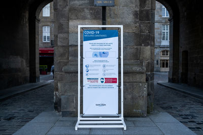 Information sign on footpath by street in city