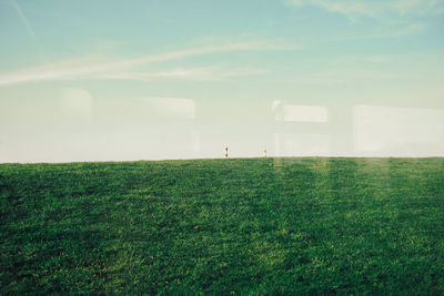 2 red white poles on empty green meadow