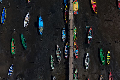 Directly above shot boats moored on sand 