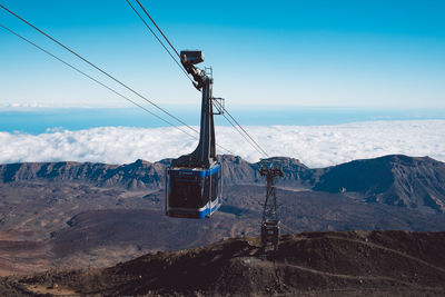 Overhead cable car on mountain against sky