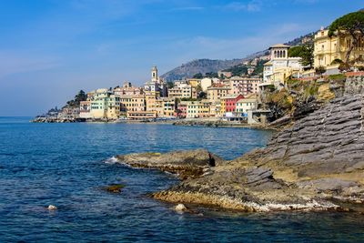 Scenic view of sea by buildings against sky