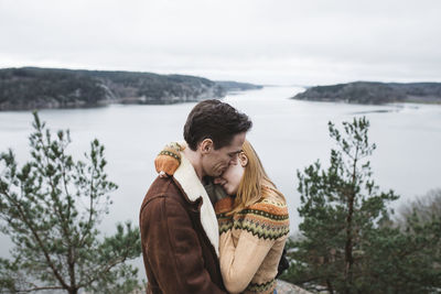 Couple hugging, sea in background