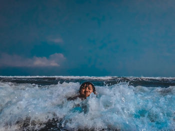 Portrait of man swimming in sea against sky