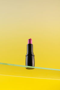 Close-up of red lipstick against yellow background