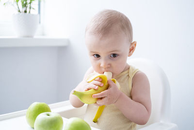 Portrait of cute baby boy eating food on table