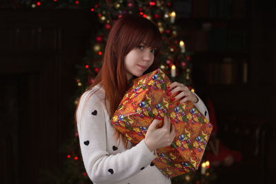 Portrait of young woman holding christmas present
