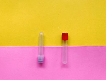 Close-up of blue paint on table against yellow wall