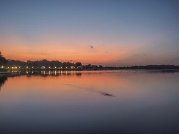 Scenic view of lake against sky at sunset