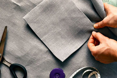 Woman is sketching pattern on a linen fabric seamstress basting and sewing in a small studio